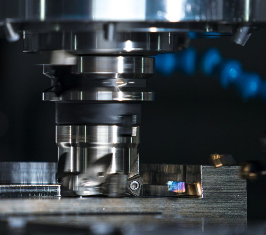 高速机加工中伺服响应速度对加工质量的影响与优化方案 High-precision milling machine cutting a metal piece, showcasing industrial machinery.